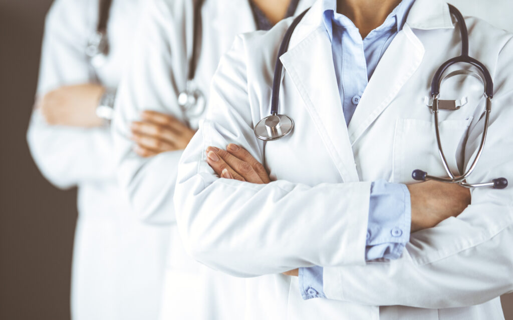 Doctors wearing white coats and stethoscopes standing in a line